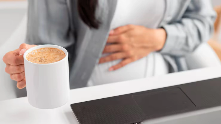 high-angle-pregnant-woman-with-laptop-coffee-mug-working-from-home_23-2148765085